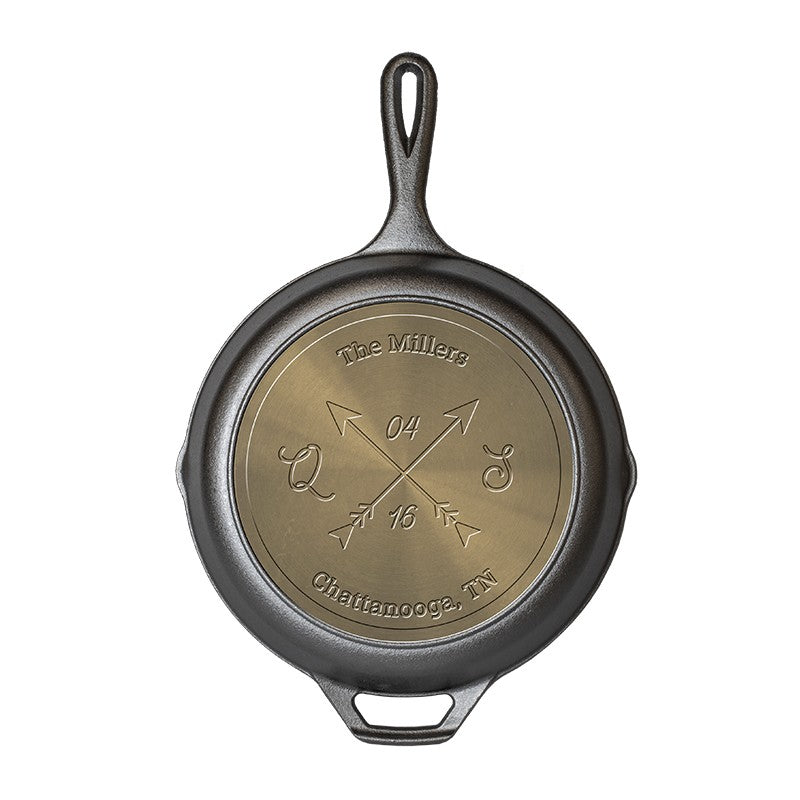 Personalized skillet featuring two crossed arrows with six editable text fields: custom text along the top and bottom curves, initials on the left and right of the arrows, and a customizable month and year above and below the arrow intersection.