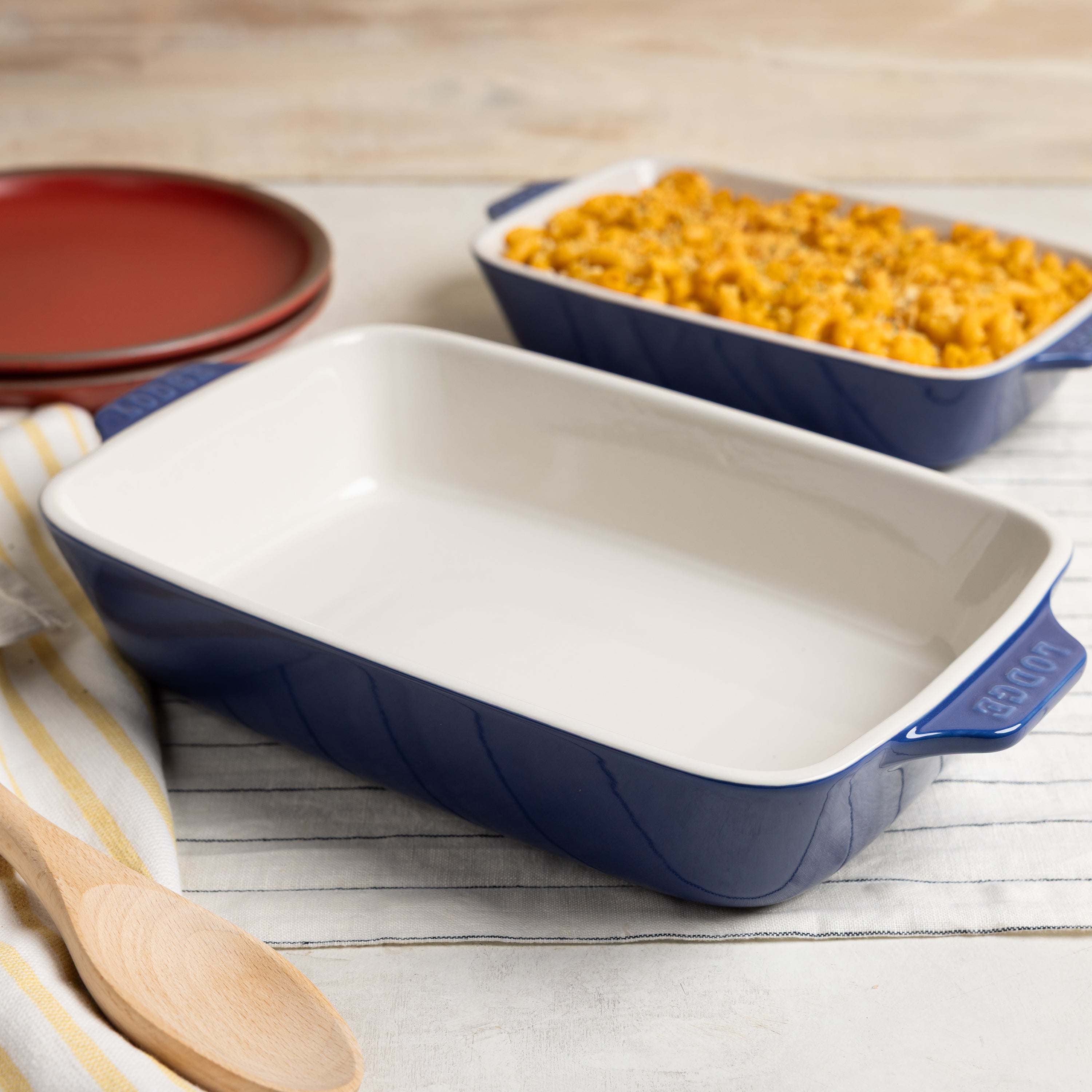 Indigo ceramic casserole dish beside freshly made Macaroni and cheese.