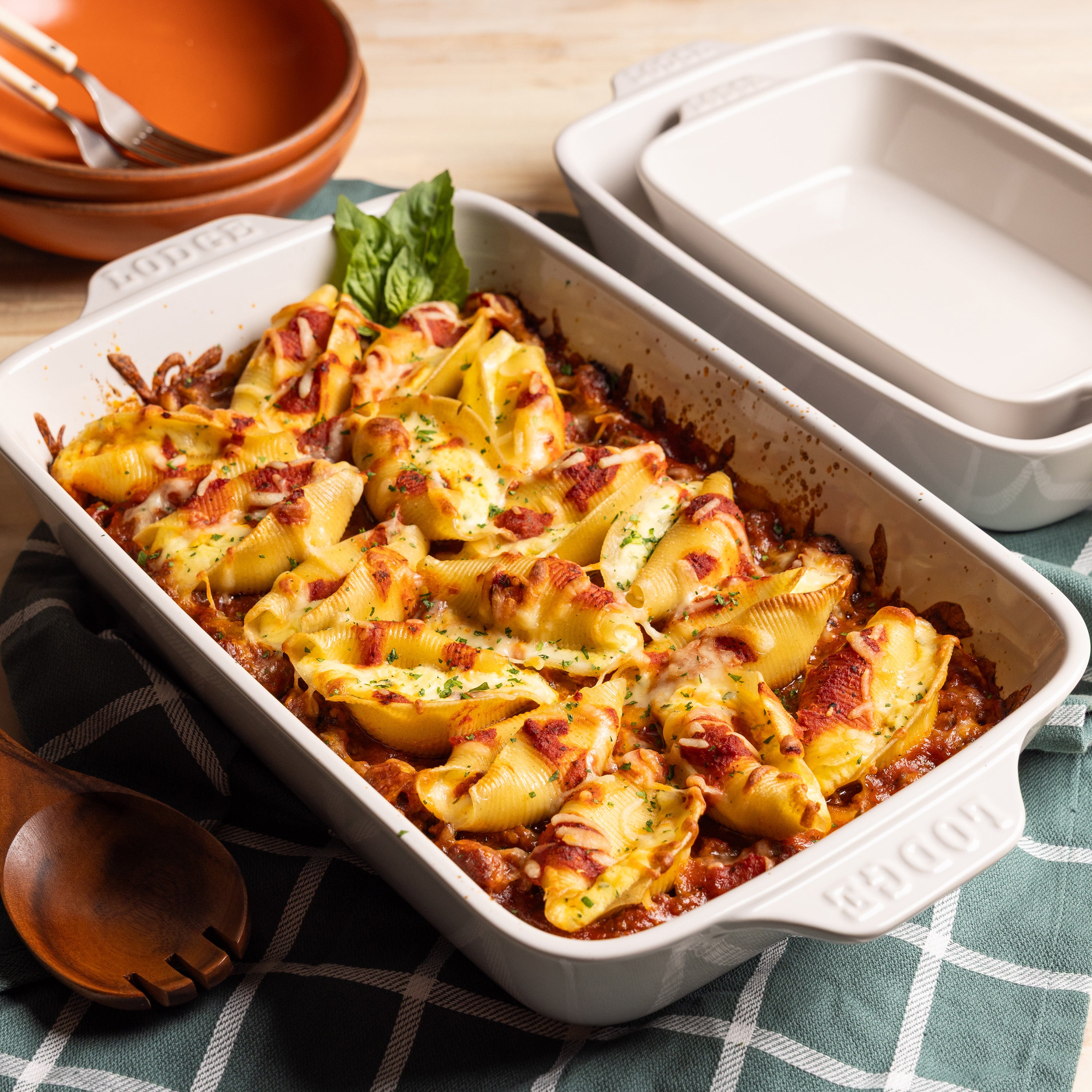 Baked pasta in oyster-colored casserole dish on checkered tablecloth.
