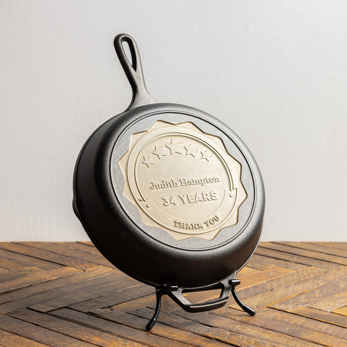 Cast iron skillet with engraved message on a wooden surface