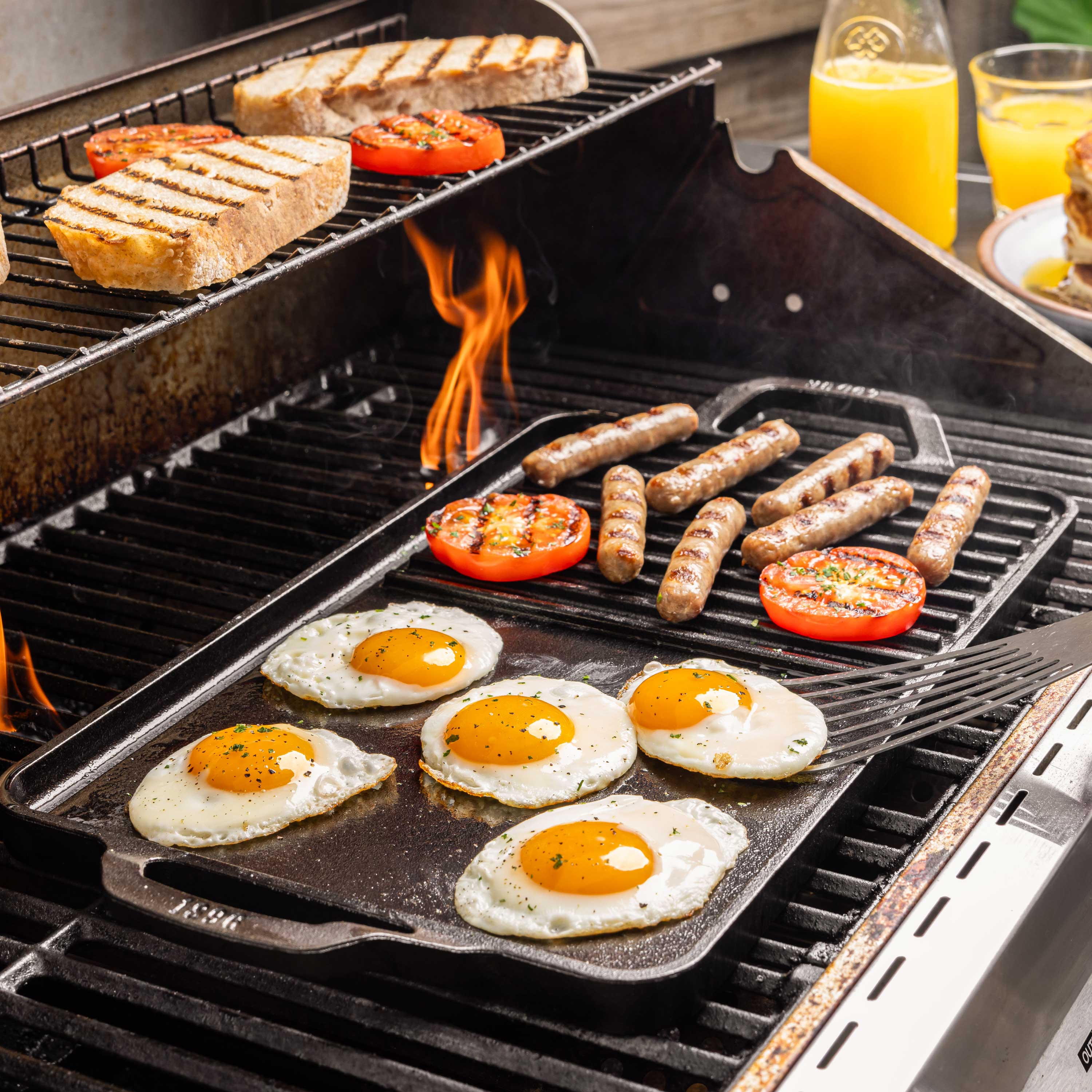 Grilling eggs and sausage on a flattop griddle combo on a grill