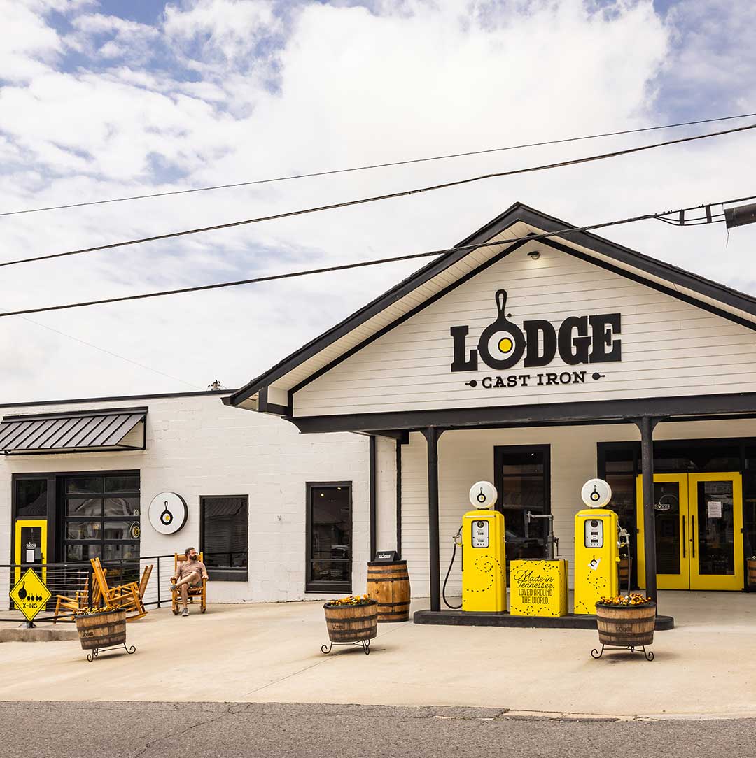 Lodge Cast Iron store front with vintage yellow gas pumps and wooden barrels.