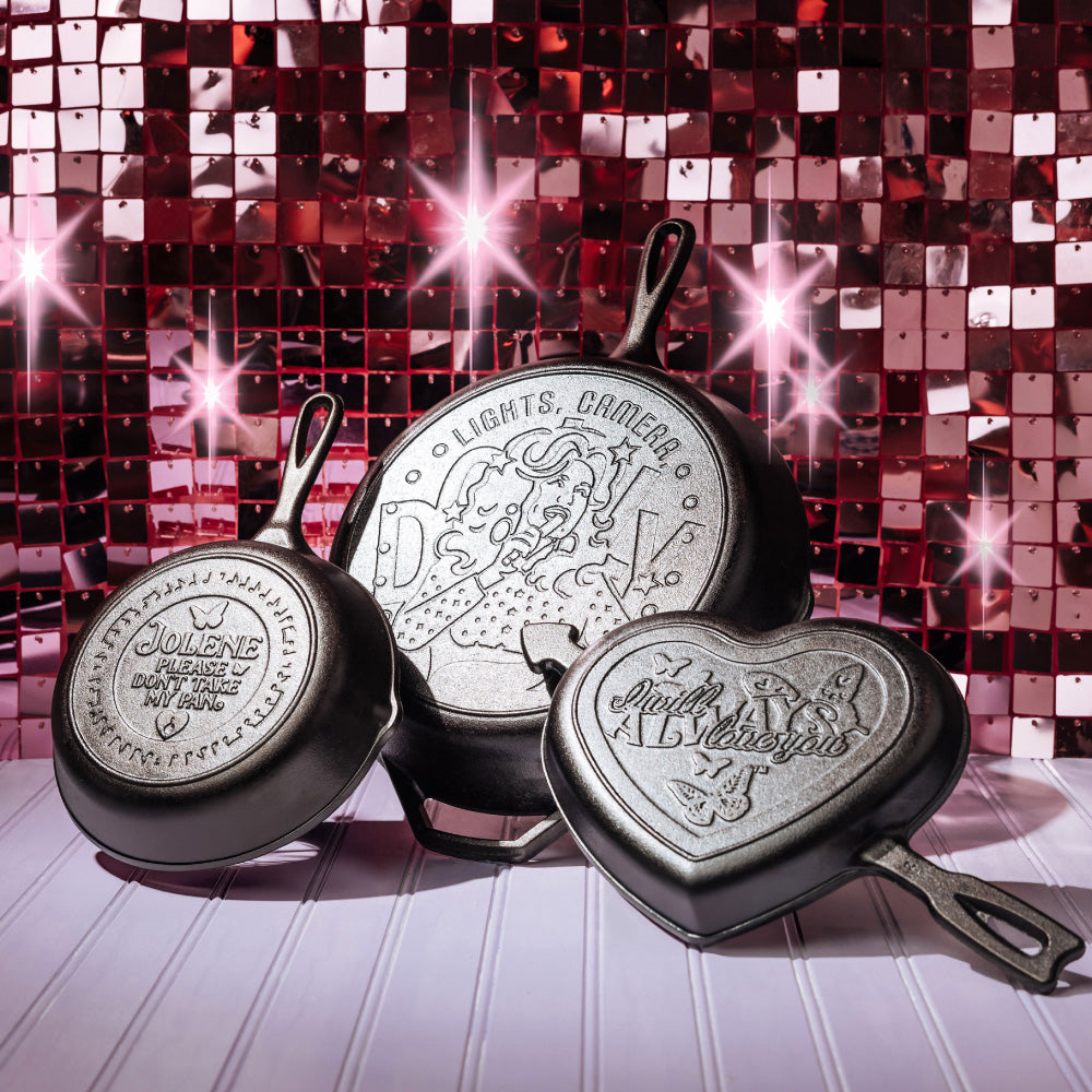 Three cast iron skillets with engraved designs on a pink sequin background