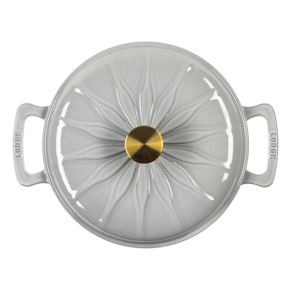 Top down view of enameled cast iron pot with a matching lid, featuring a central gold knob and white radial lines on the lid.