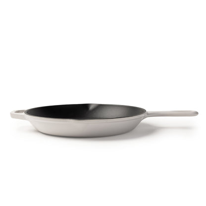 A white cast iron skillet with a black non-stick interior and a single white handle, shown on a clean white background.