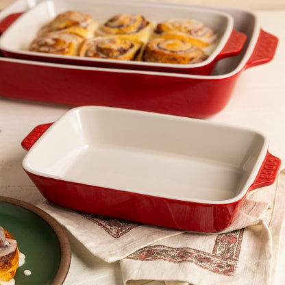 Cherry red ceramic baking dish beside baked goods.