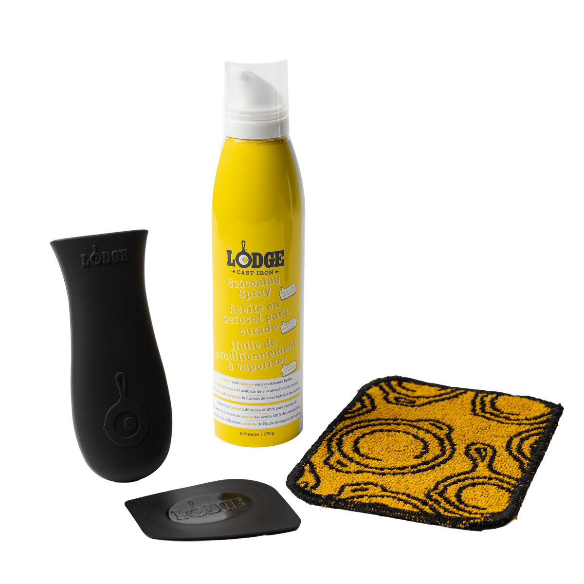 4 piece care set with a black silicone handle holder, black pan scraper, scrub cloth, and a bottle of seasoning spray.