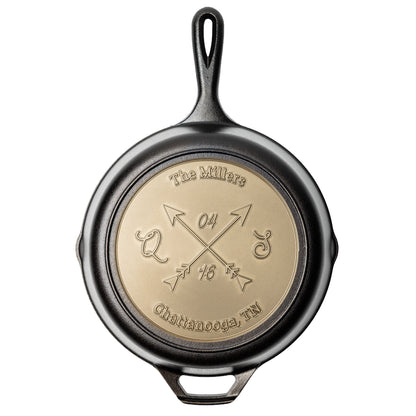 Personalized skillet featuring two crossed arrows with six editable text fields: custom text along the top and bottom curves, initials on the left and right of the arrows, and a customizable month and year above and below the arrow intersection.