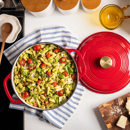 Red cookware with pasta dish on a kitchen counter