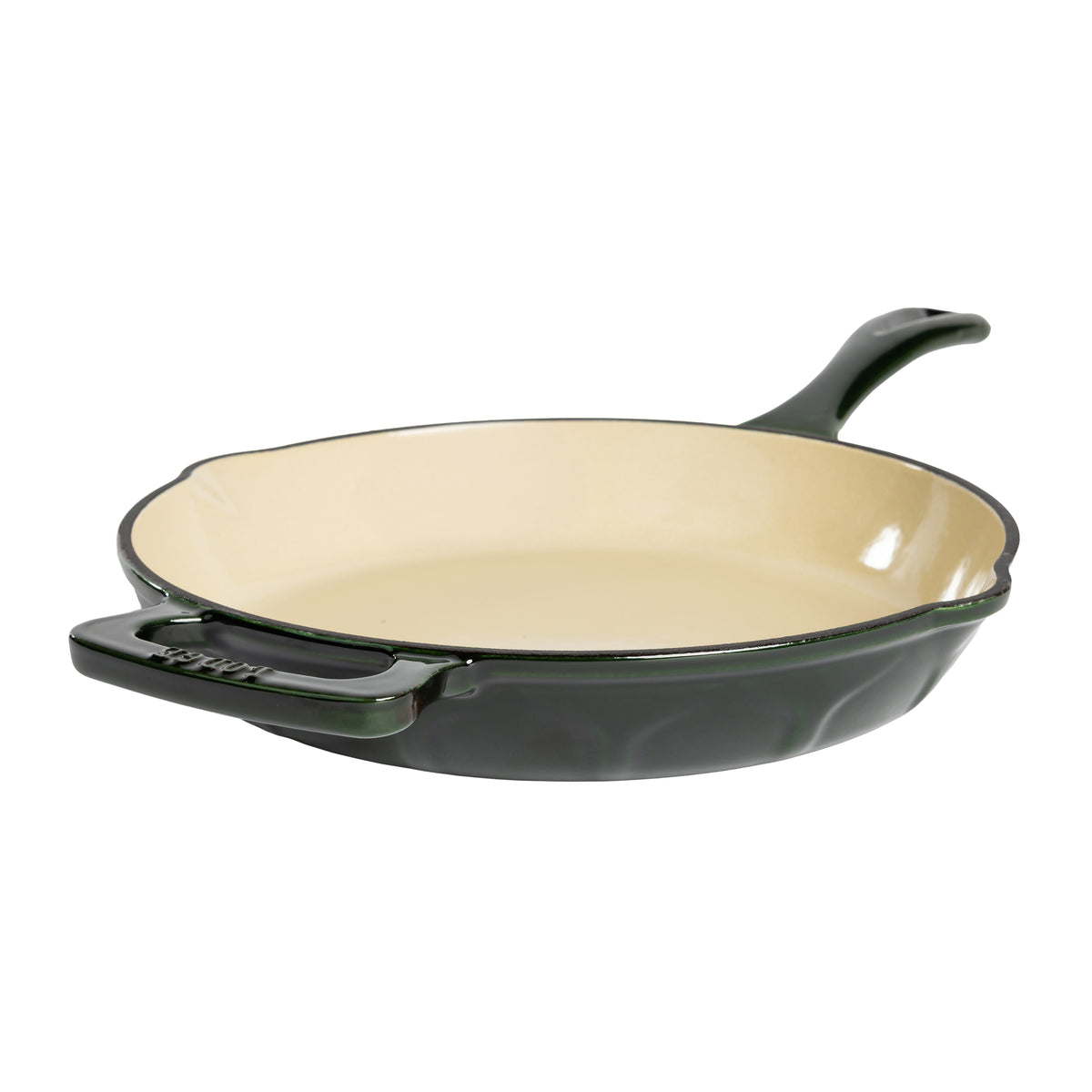 A green enameled cast iron skillet with a cream-colored interior and a black rim, shown from a three-quarters angle on a white background.