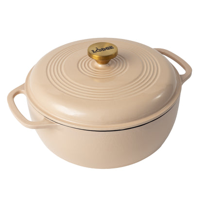 Latte cream enameled cast iron Dutch oven including a lid with gold knob.