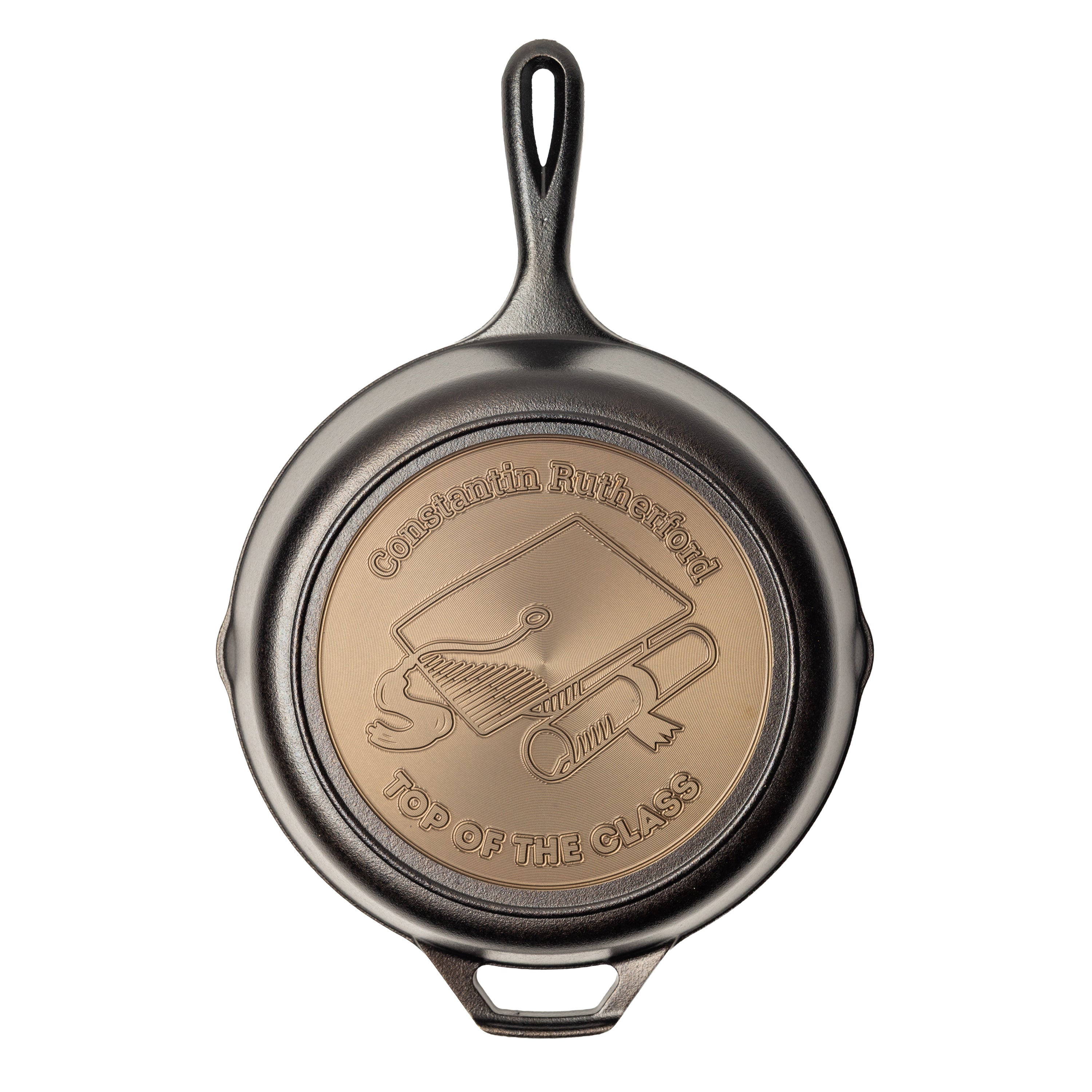 Personalized graduation skillet featuring an engraved graduation cap and diploma centered on the skillet with two editable text fields on the top and bottom arc.