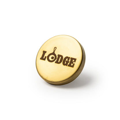 A round, gold colored knob engraved with the word 'LODGE'.