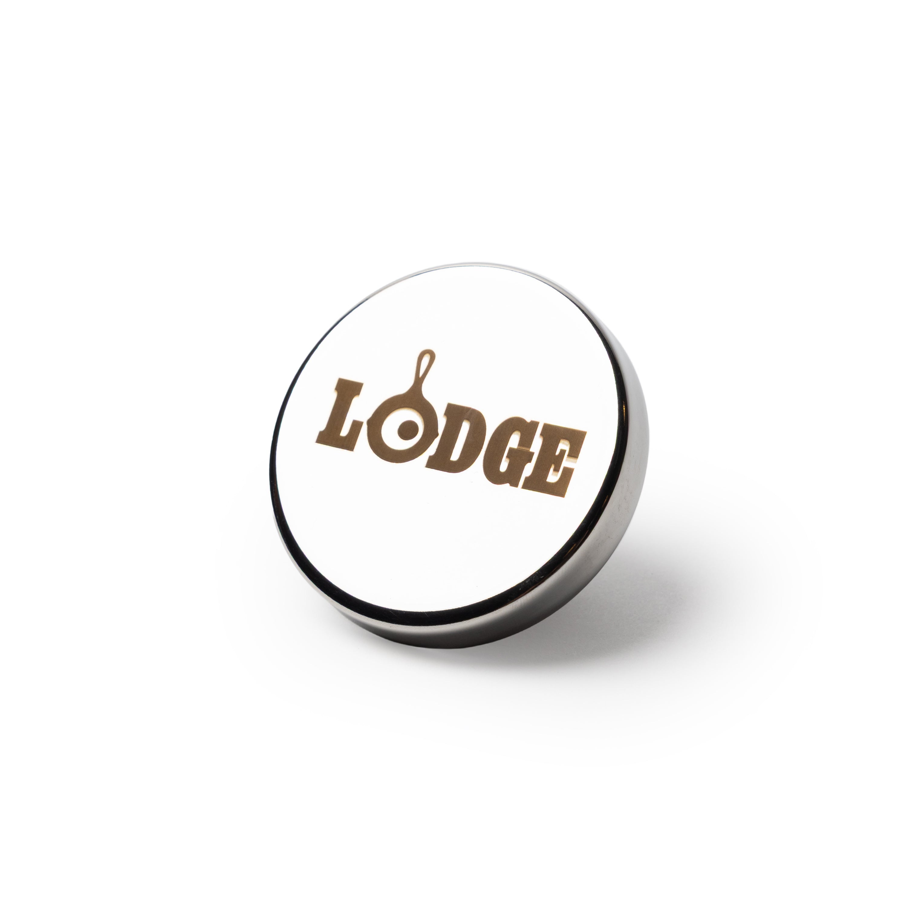 A round, stainless silver colored knob engraved with the word 'LODGE'.