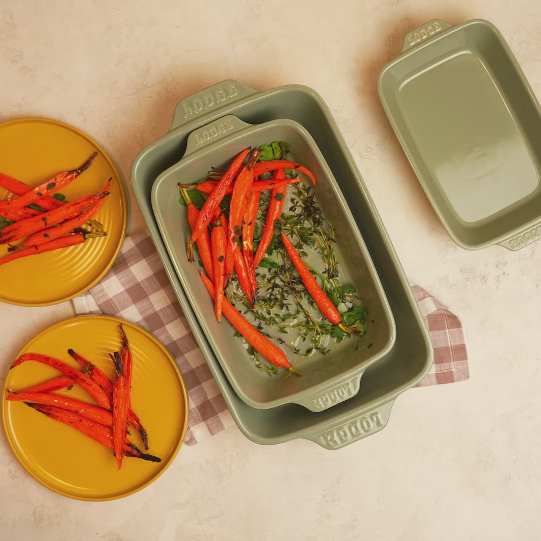 Roasted carrots being served, freshly made in stoneware casserole dish.