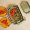 Roasted carrots being served, freshly made in stoneware casserole dish.