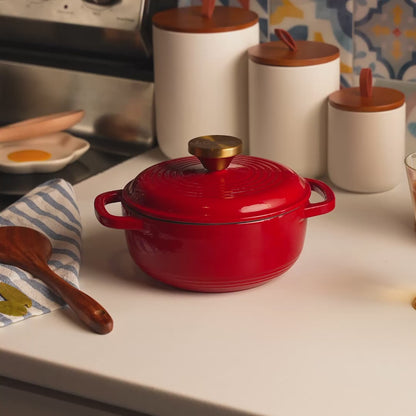 Someone removing the lid of dutch oven featuring a fresh dish of baked beans.