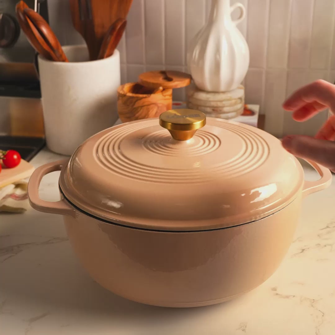 Someone removing lid to reveal freshly prepared pesto pasta salad.