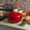 Someone removing lid on dutch oven revealing freshly made pasta salad.