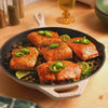Close up view of freshly prepared salmon, made and served in skillet.