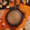 Close up view of a sample skillet used for graduation, with confetti falling on top of skillet.