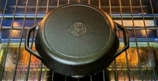 A Lodge cast iron pan is placed upside down in the oven to bake.